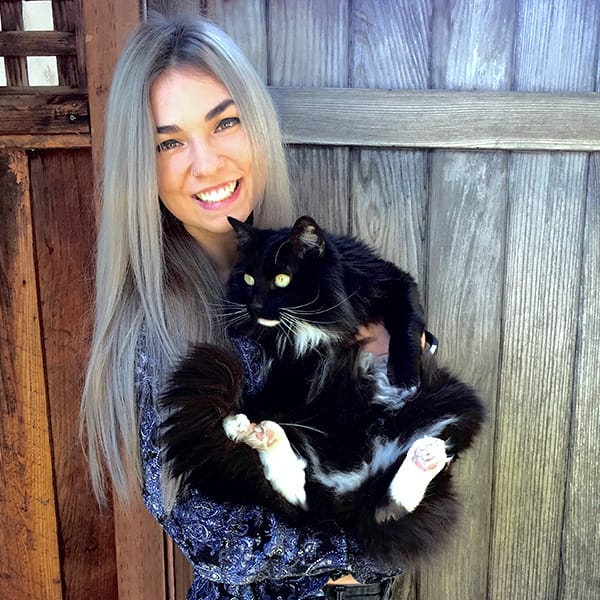 Portrait of Alina Chetcuti holding her black and white cat.