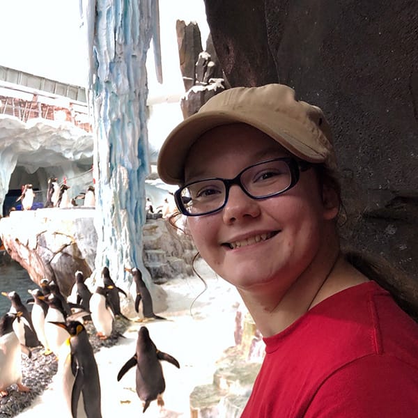 Portrait of Breah Morgan smiling with Penguins in the background.